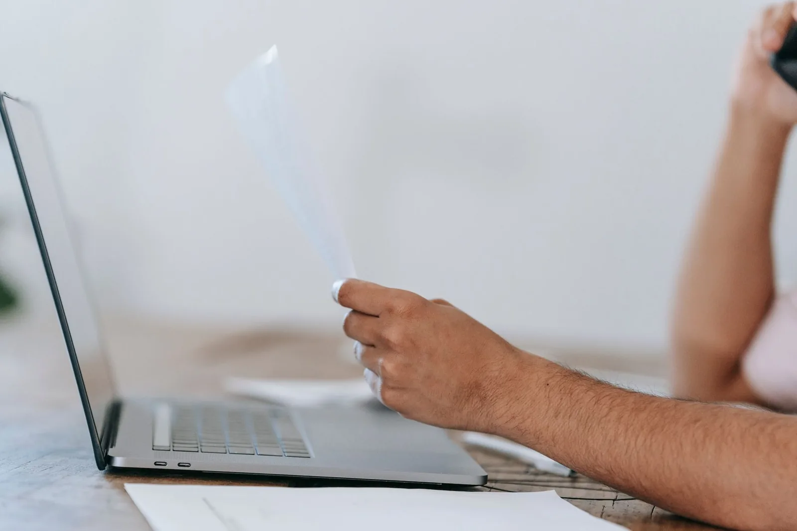 Ruka kuva na laptopu sa otvorenim Word dokumentom za cenovnik